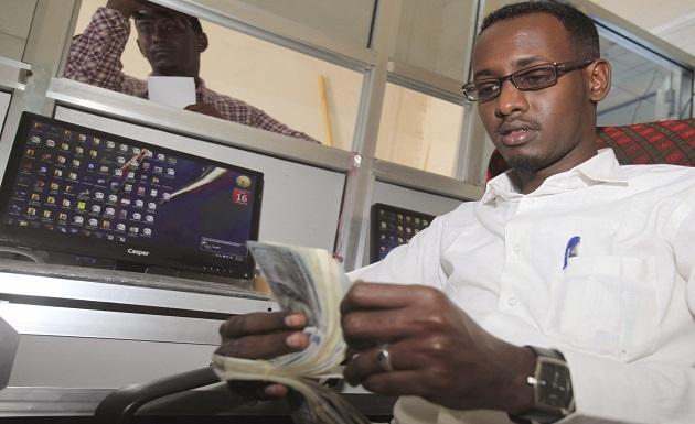 A worker at the Dahabshill money transfer office counts U.S. notes in capital Mogadishu February 16, 2015. (REUTERS/Omar Faruk)